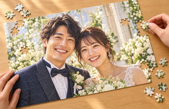 二人の写真パズルをテーブルの上で組み立てる手元