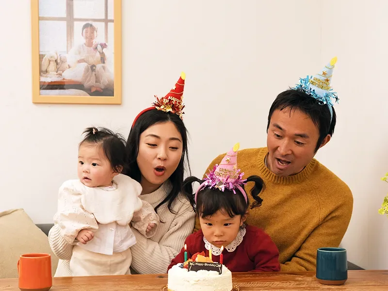 子どもの写真パズルを壁に飾った家族の誕生日シーン