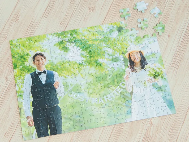 木の天板に置いた新郎新婦の写真パズル。数ピースを外して、写真とパズルの質感が見える実物例