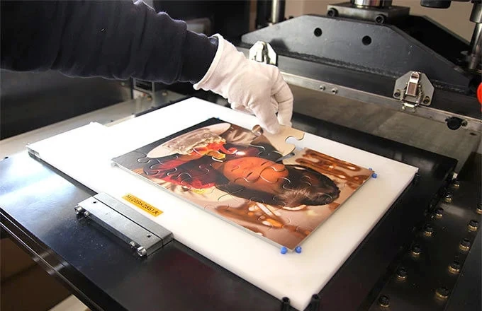 シャフトの職人が工房で写真パズルを製作している様子